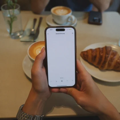 Celular na mão em cima da mesa do café